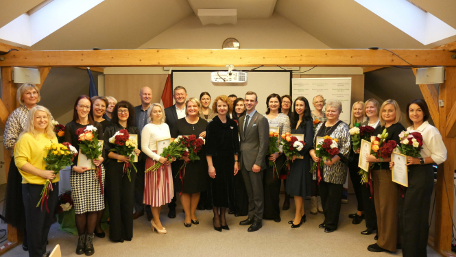 Kopbilde no pasākuma, kurā redzama liela cilvēku grupa — apbalvojumu saņēmēji.