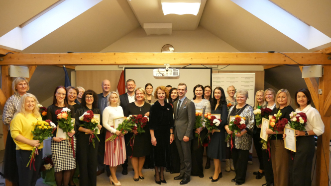 Kopbilde no pasākuma, kurā redzama liela cilvēku grupa — apbalvojumu saņēmēji.