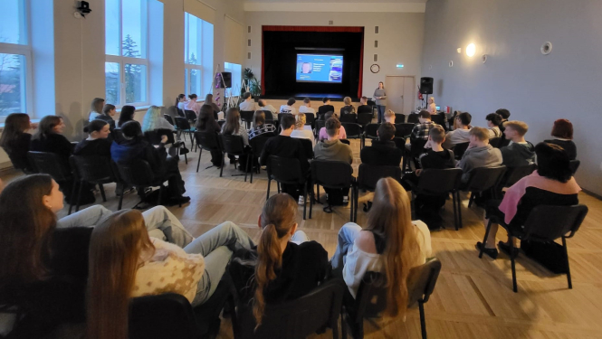 Jaunieši piedalās interaktīvā darbnīcā, diskutē un strādā pie uzdevumiem auditorijā.