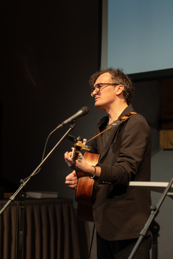 Mūziķis spēlē ģitāru uz skatuves