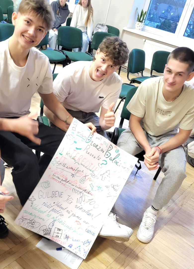 Jaunieši piedalās interaktīvā darbnīcā, diskutē un strādā pie uzdevumiem auditorijā.