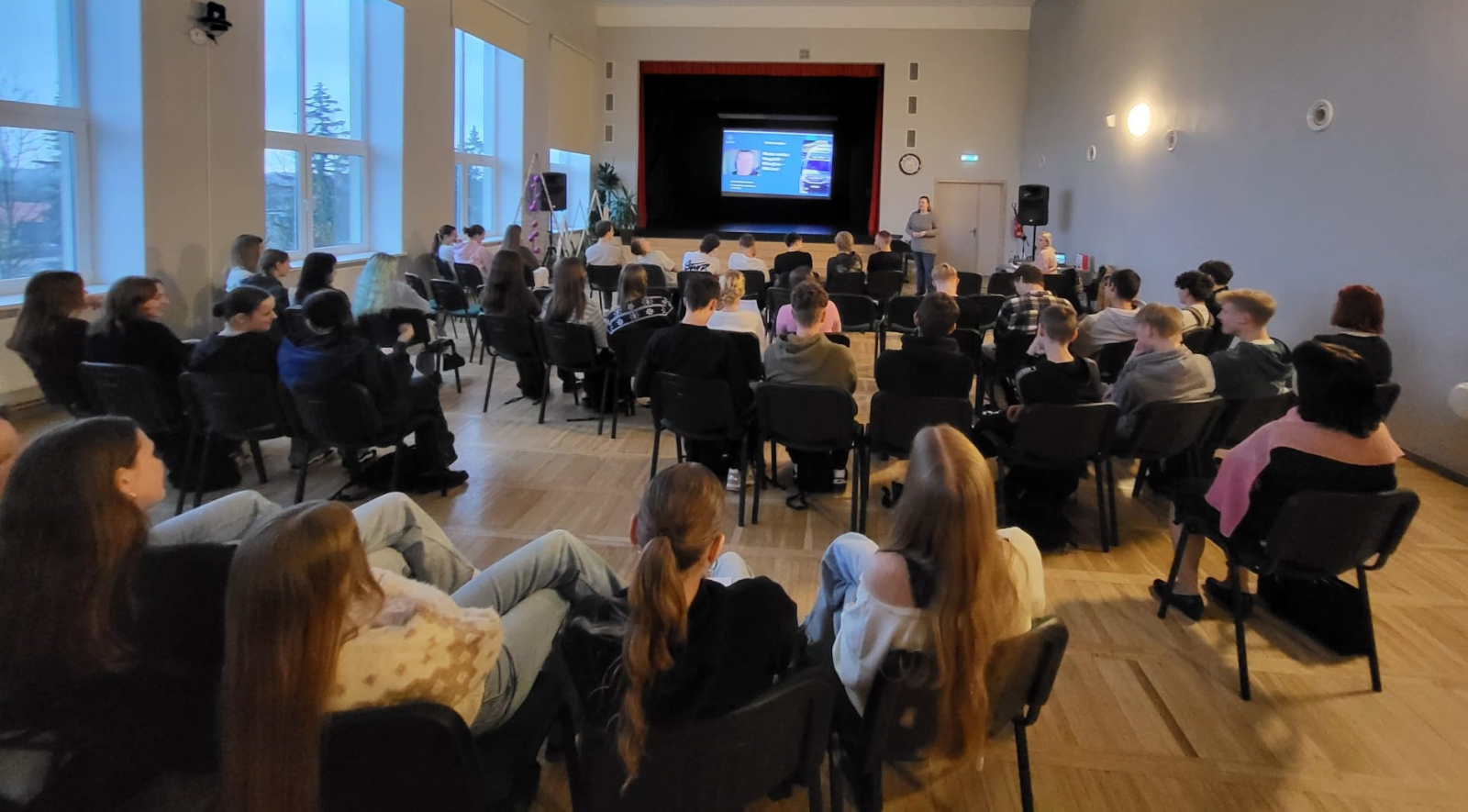 Jaunieši piedalās interaktīvā darbnīcā, diskutē un strādā pie uzdevumiem auditorijā.