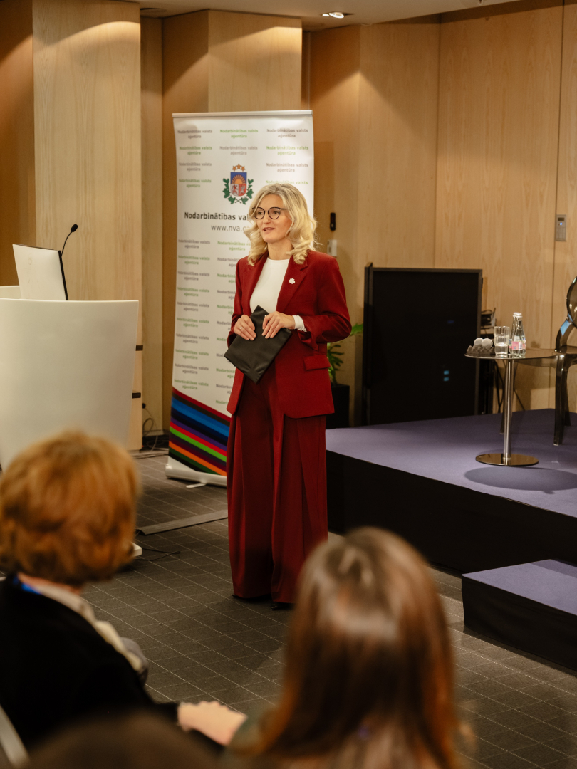 Konferences “Brīvprātīgais darbs Latvijā — vakar, šodien un rīt” foto ar plašu auditoriju, skatuvi un runātāju.