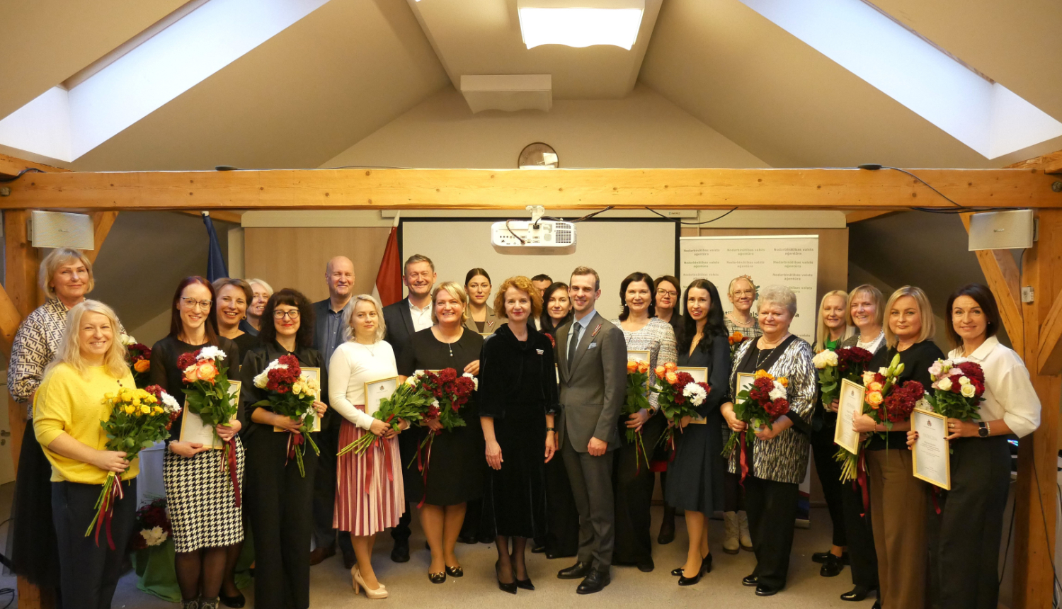 Kopbilde no pasākuma, kurā redzama liela cilvēku grupa — apbalvojumu saņēmēji.