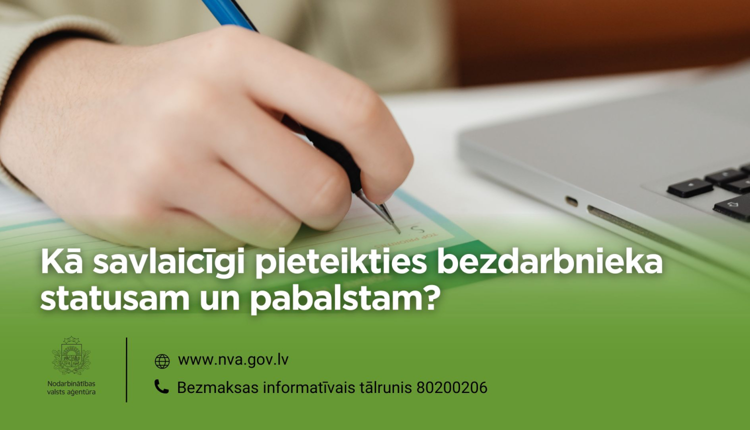 Cilvēks raksta iesniegumu uz papīra pie atvērta klēpjdatora